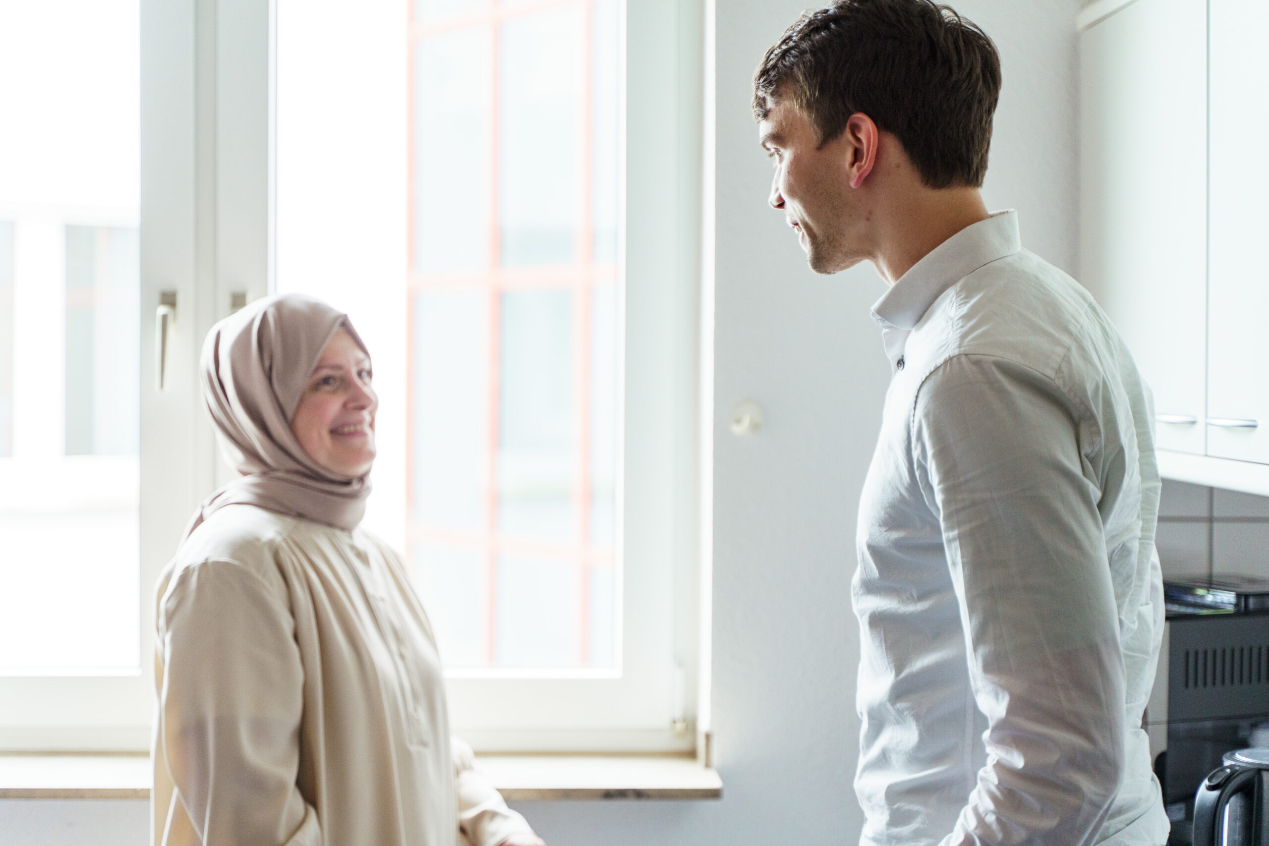 Mann und Frau im Gespraech vor einem Fenster